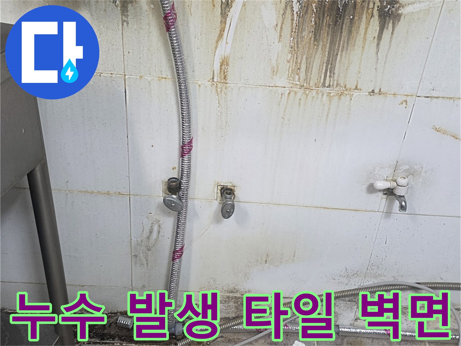 배관 주변의 젖은 타일과 오염된 벽면을 촬영한 사진