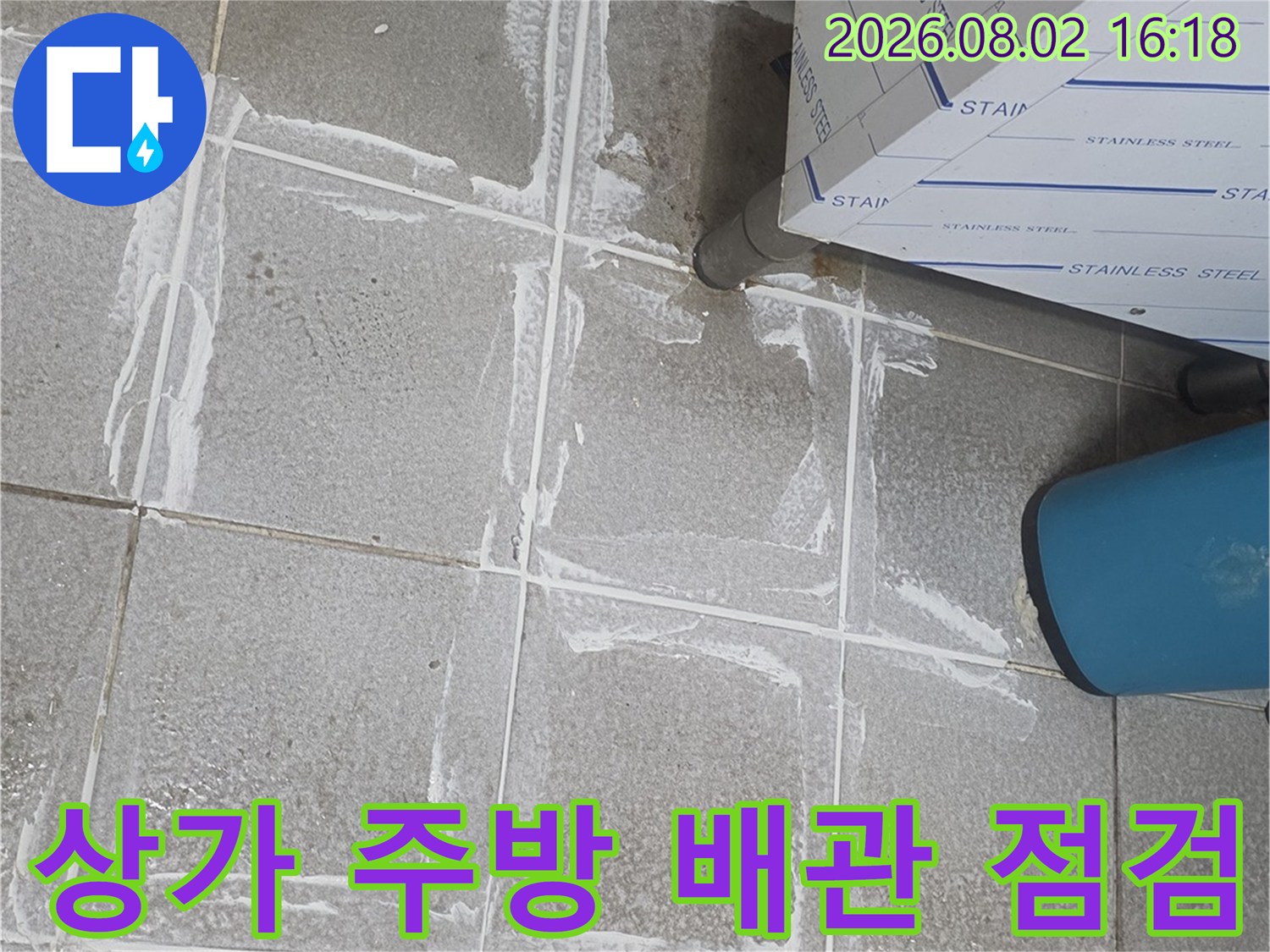 타일 바닥에 표시된 누수 지점과 노출된 배관 연결 부위