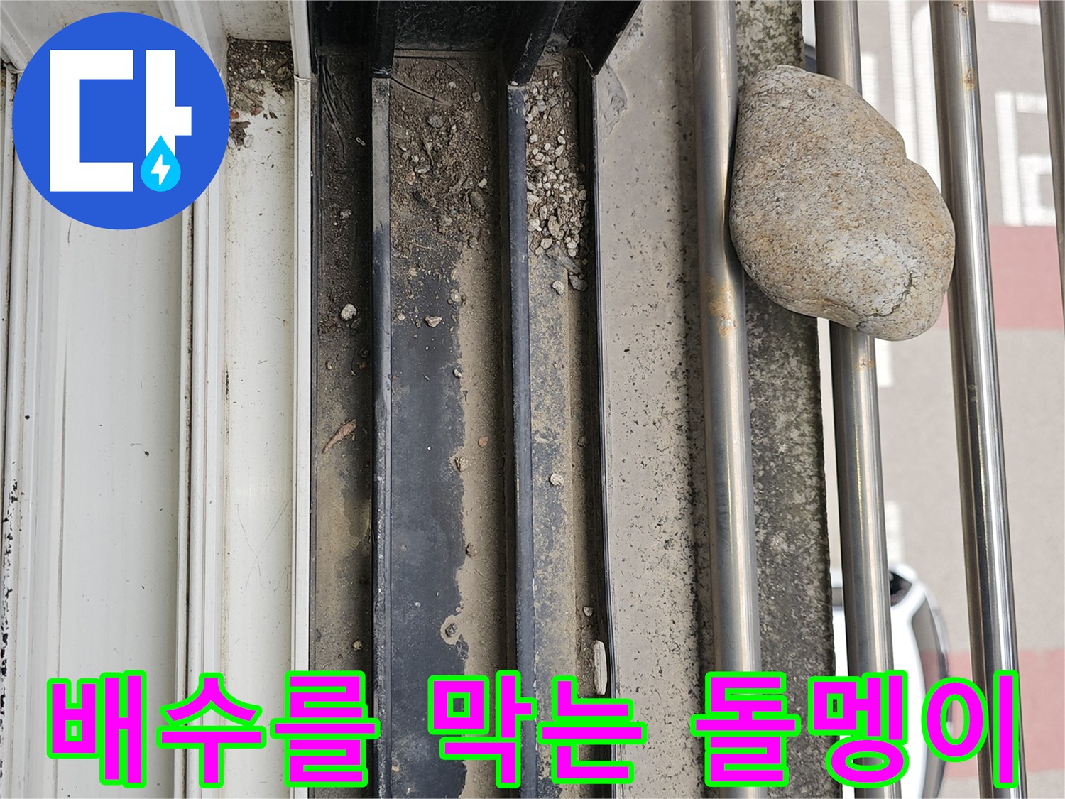 금속 프레임 구조물 사이에 끼어 있는 큰 돌과 퇴적된 흙
