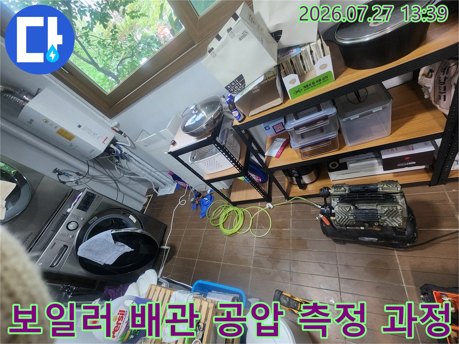 보일러실 바닥에 배치된 누수 탐지용 기계-노란색 호스가 연결되어 배관을 점검하는 장면