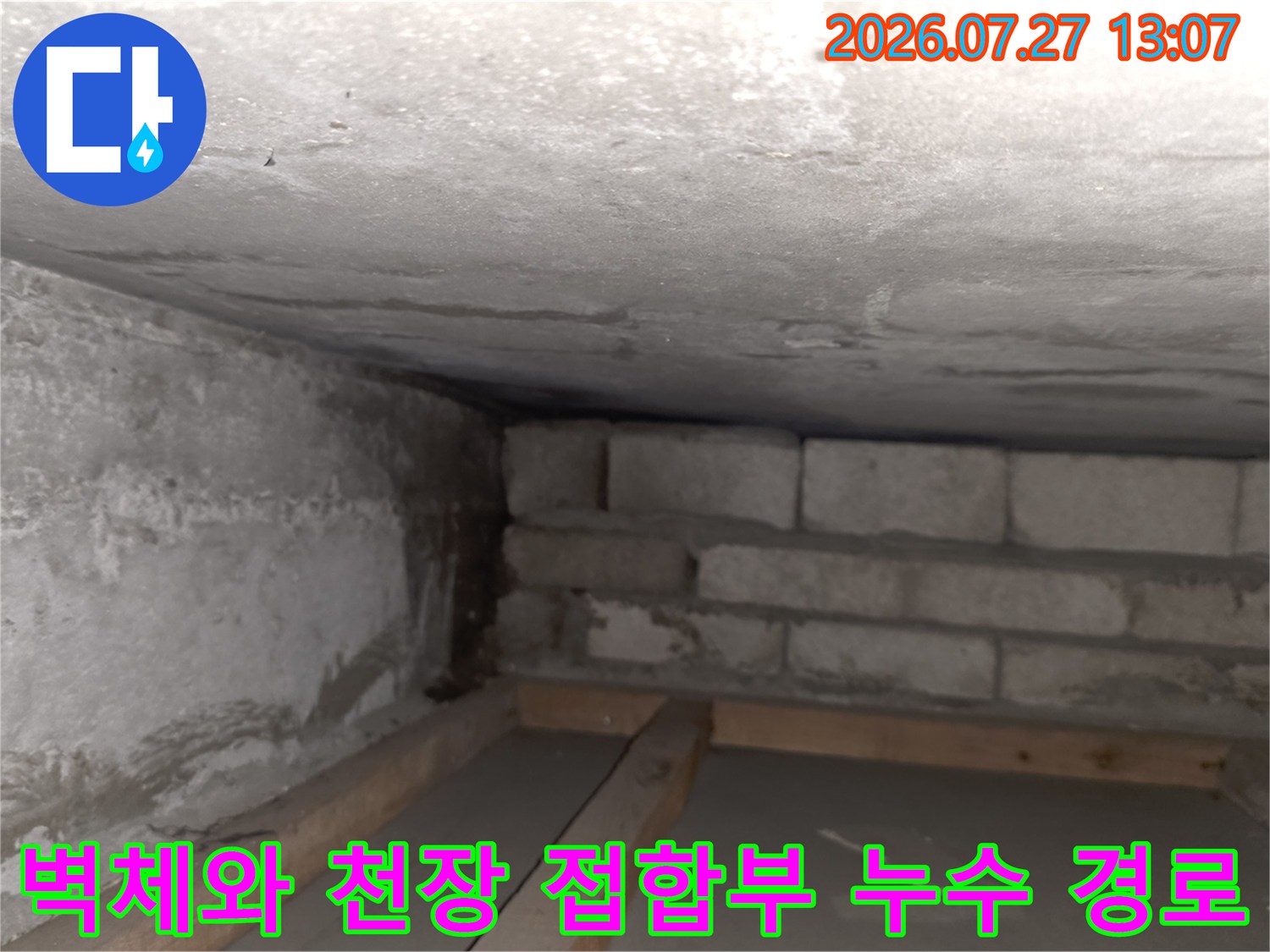 목재 구조물 위로 보이는 콘크리트 천장과 블록 벽체의 습한 연결 부위