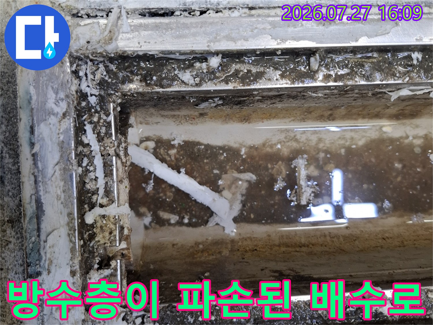 배수 트랜치 바닥면에 찌꺼기가 눌러붙어 있고 방수 마감이 떨어진 상태의 사진