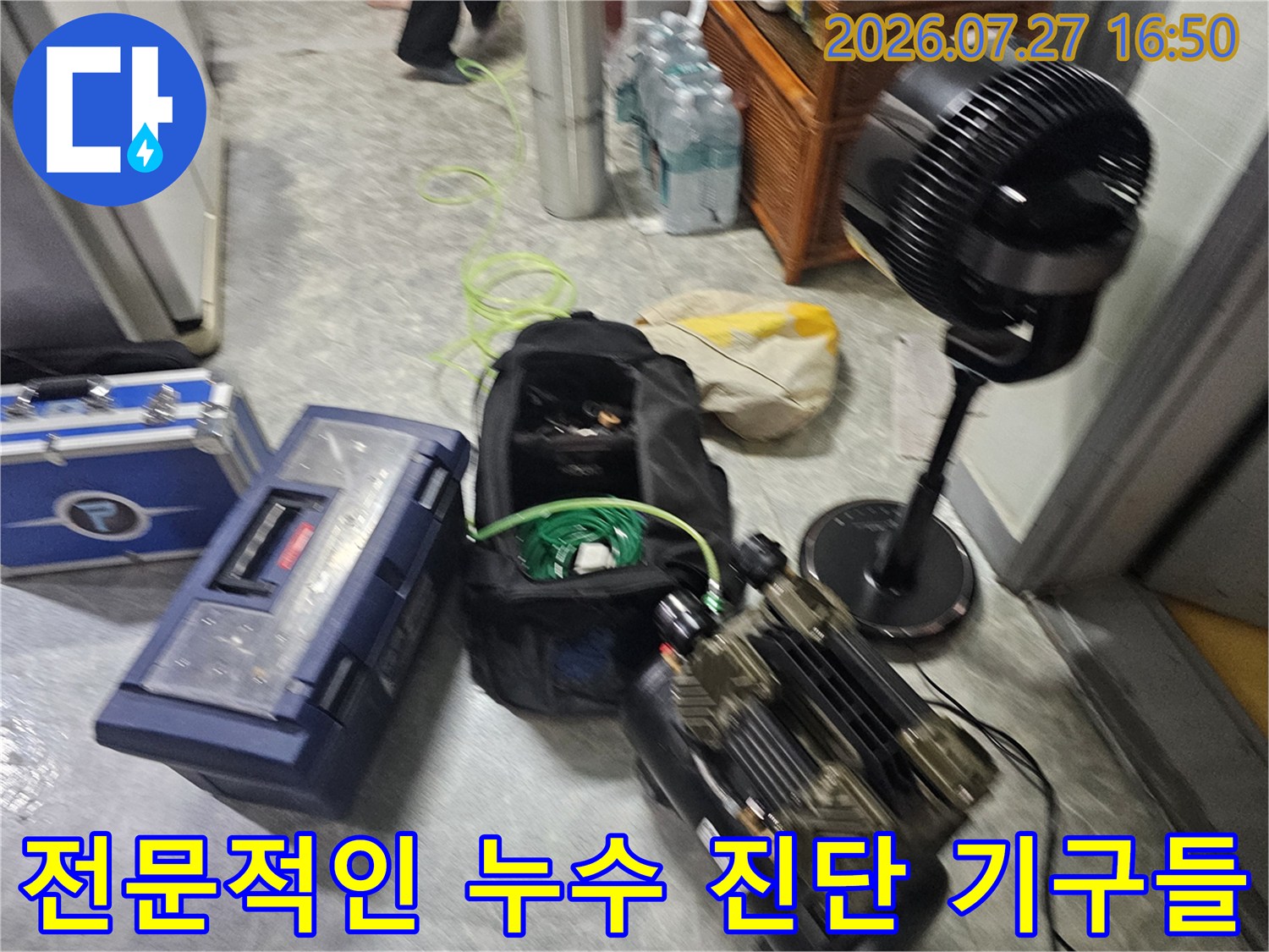 검은색 가방 속의 녹색 호스와 파란색 장비 케이스-바닥에 정렬된 전문 도구들