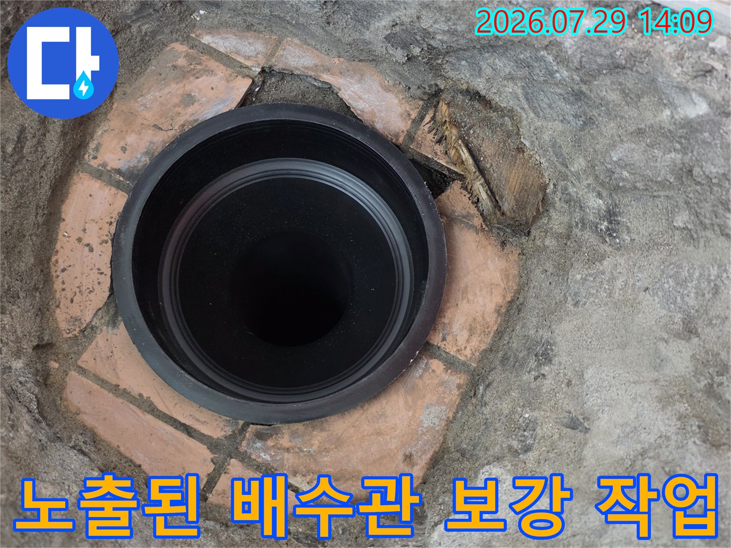 베란다 바닥에 노출된 검은색 배수관과 주변 시멘트 마감 처리 모습