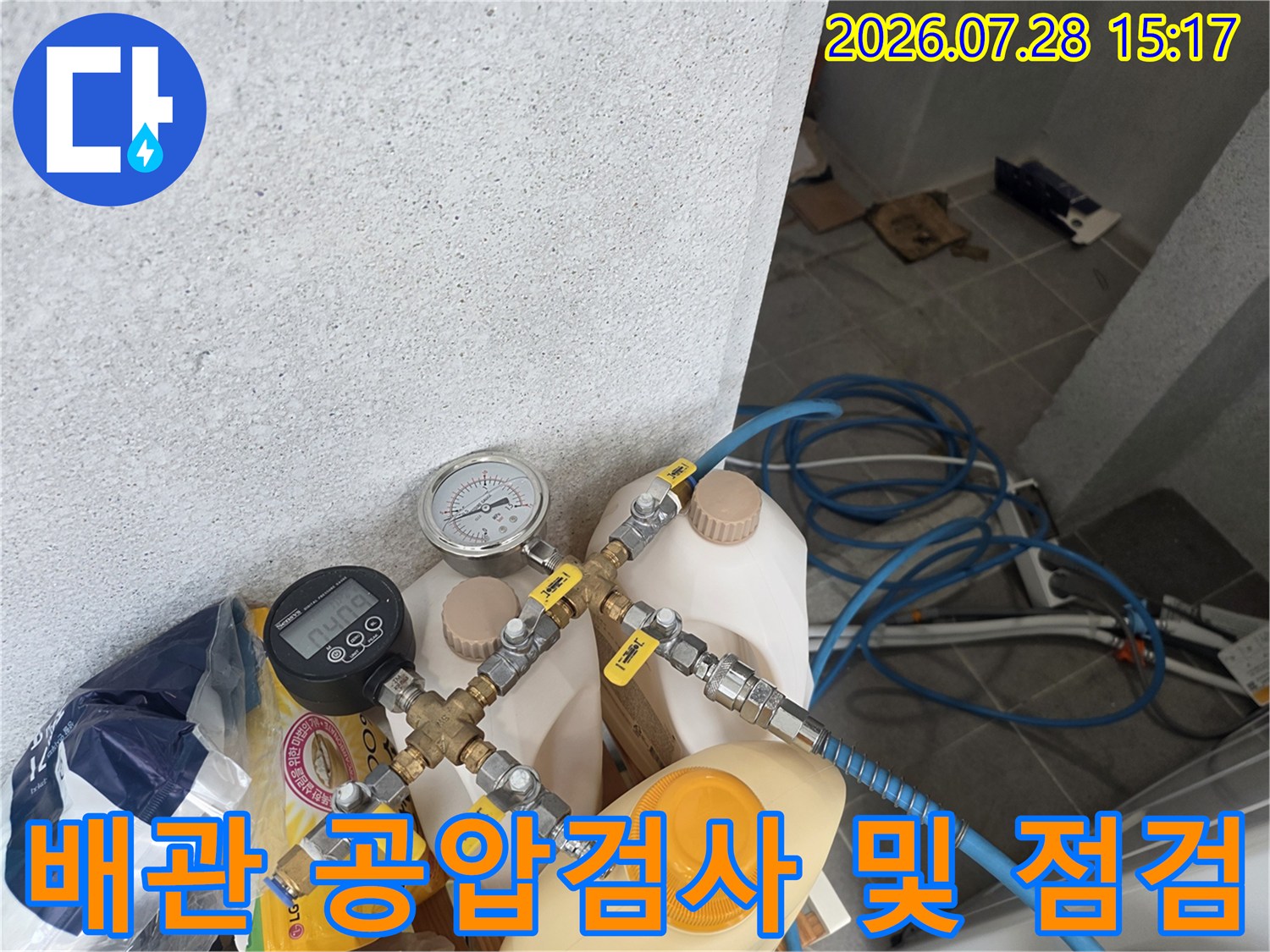 공압 검사기와 압력계가 연결된 배관 부위의 세밀한 점검 모습