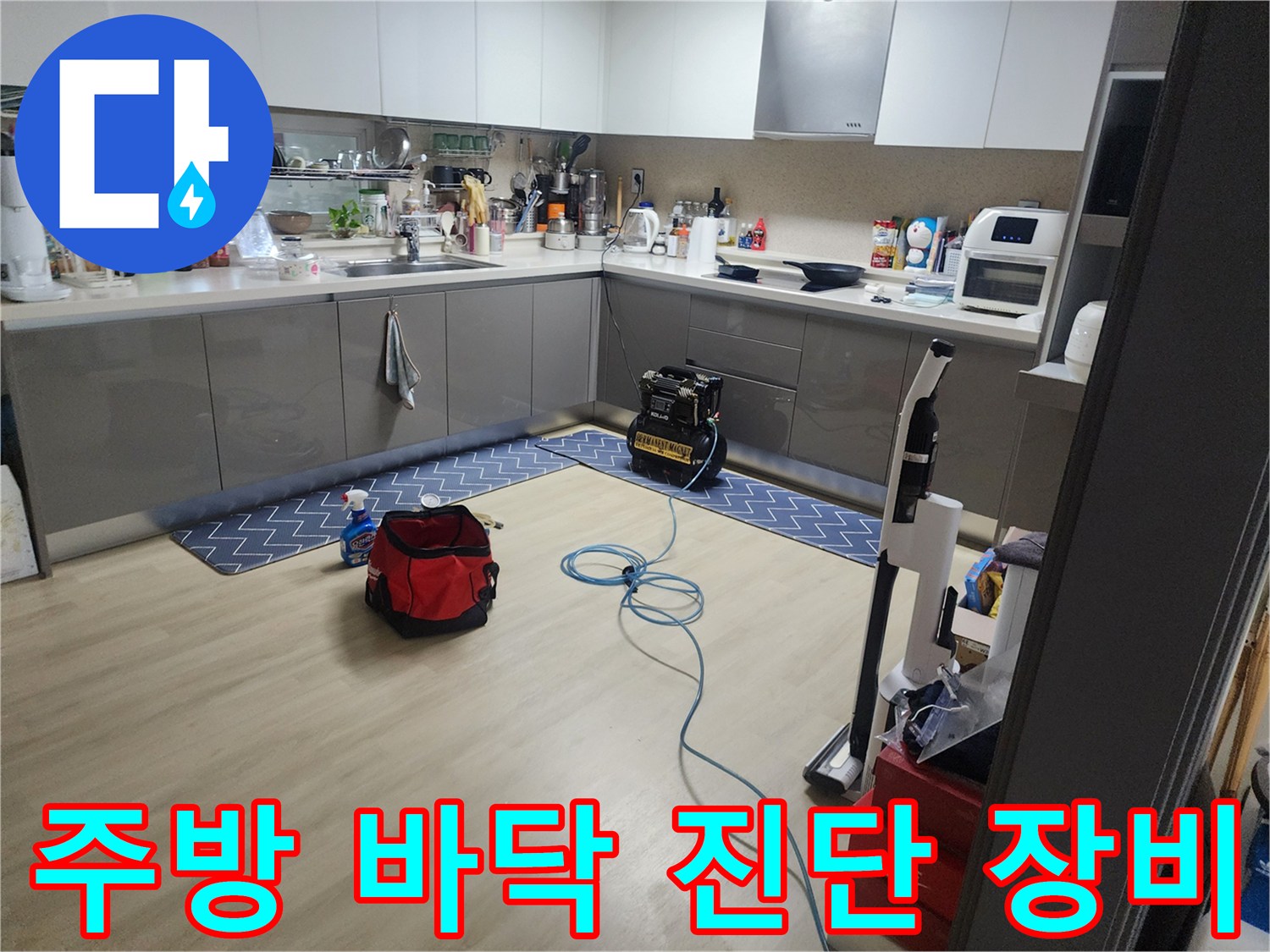 싱크대 아래쪽 바닥에 놓인 누수 탐지용 가압 펌프와 호스