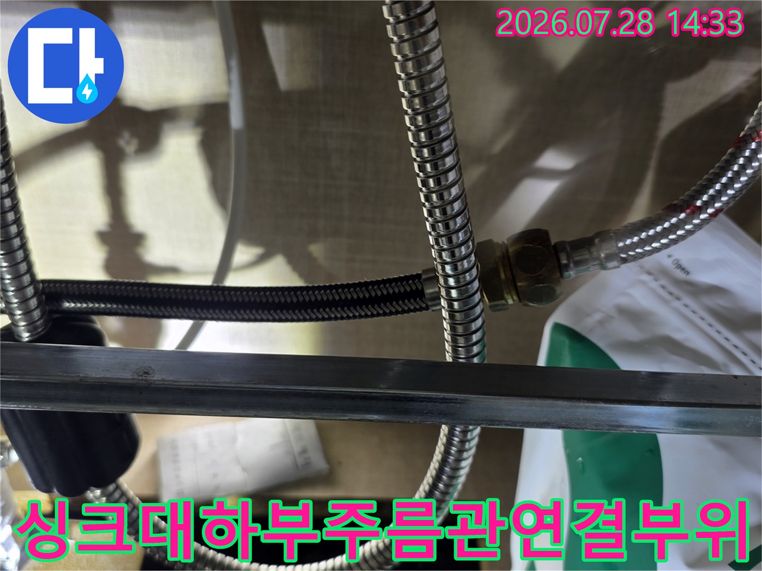 싱크대 하부의 스테인리스 주름관 연결 너트 부분에서 누수가 발생한 모습