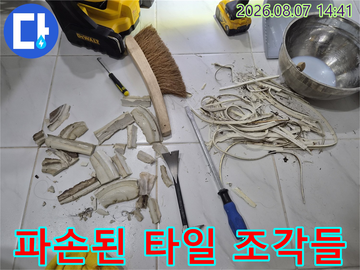 수원 영통구 화장실 보수를 위해 파손된 타일 조각과 작업 도구가 놓여 있는 모습입니다.