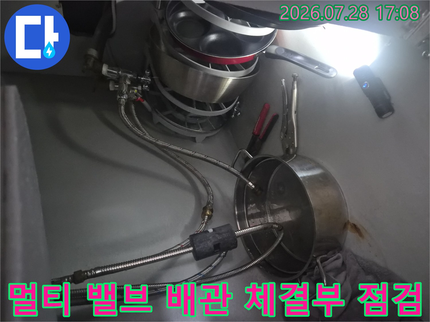 싱크대 하부에서 식기세척기 연결용 멀티 밸브를 확인하는 모습