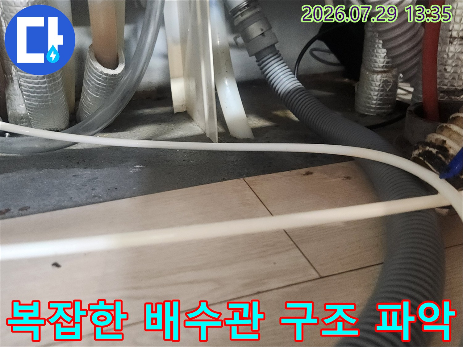 다양한 굵기의 배관이 연결된 싱크대 하부 공간의 모습