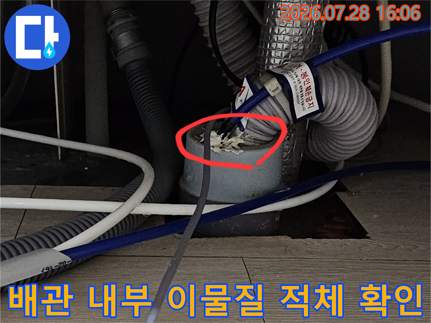 막힌 배수관 내부에 가득 찬 슬러지와 찌꺼기들을 촬영한 사진입니다.