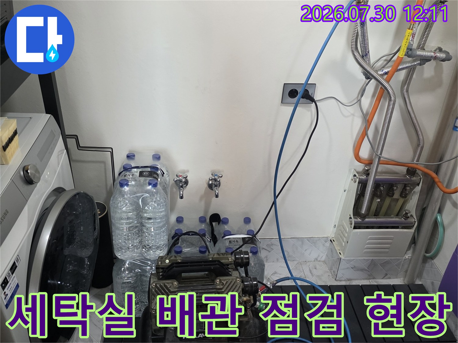 세탁실 내부에 노출된 수도 배관과 정밀 탐지 장비를 연결하여 압력 테스트를 진행하는 모습