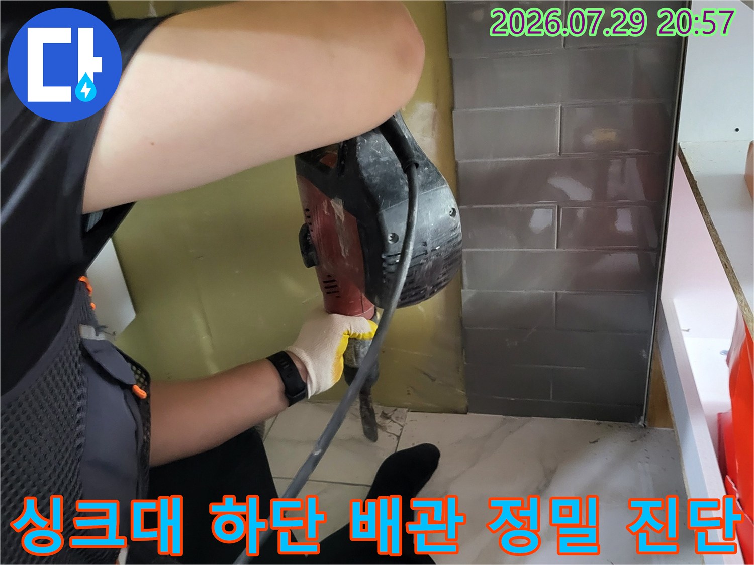 전문가가 청음 장비를 사용하여 싱크대 밑 바닥 속 누수 지점을 찾는 과정