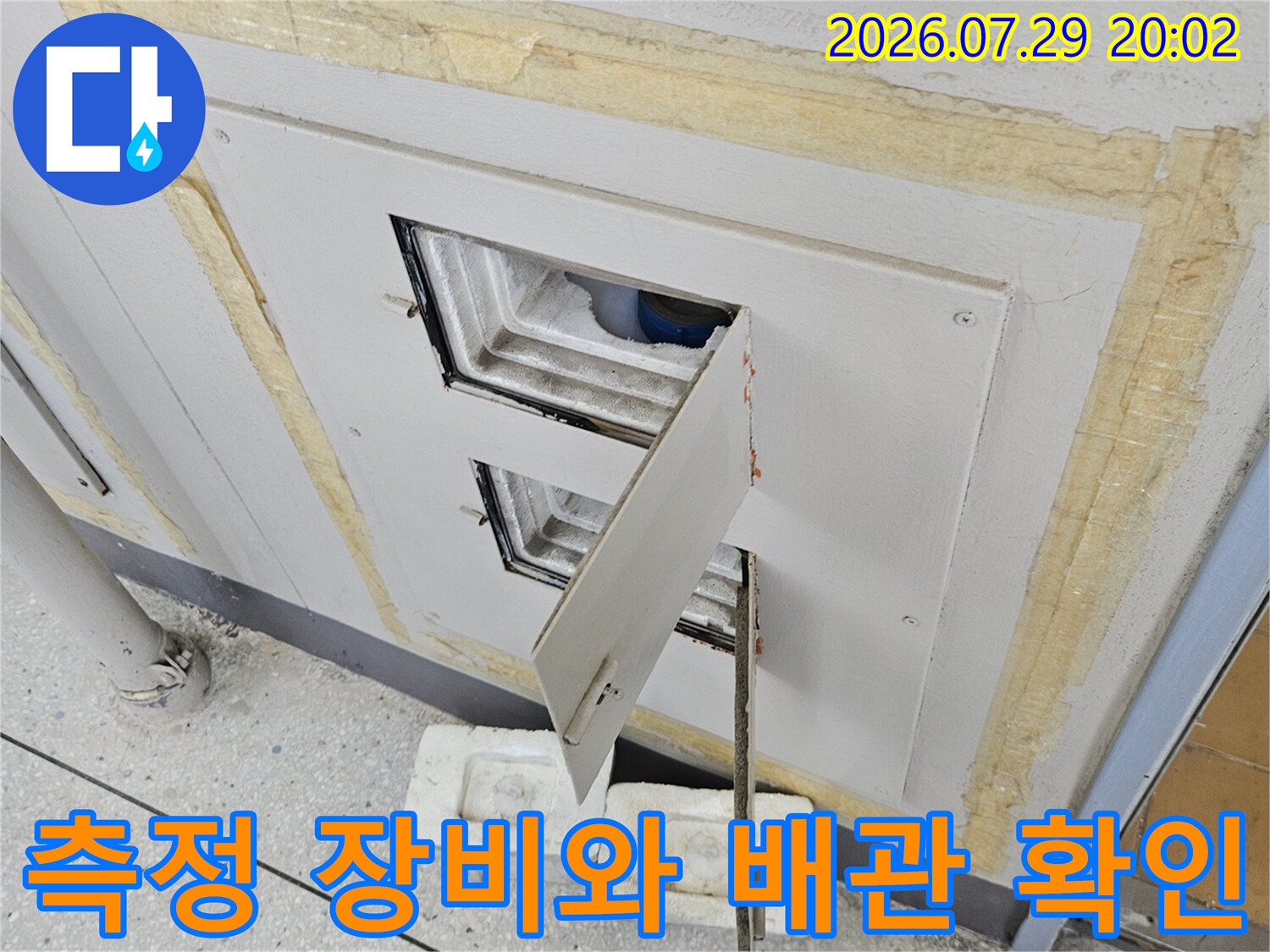 긴 탐지용 도구를 배치하여 계량기 인근의 복잡한 배관 구조를 점검하는 모습