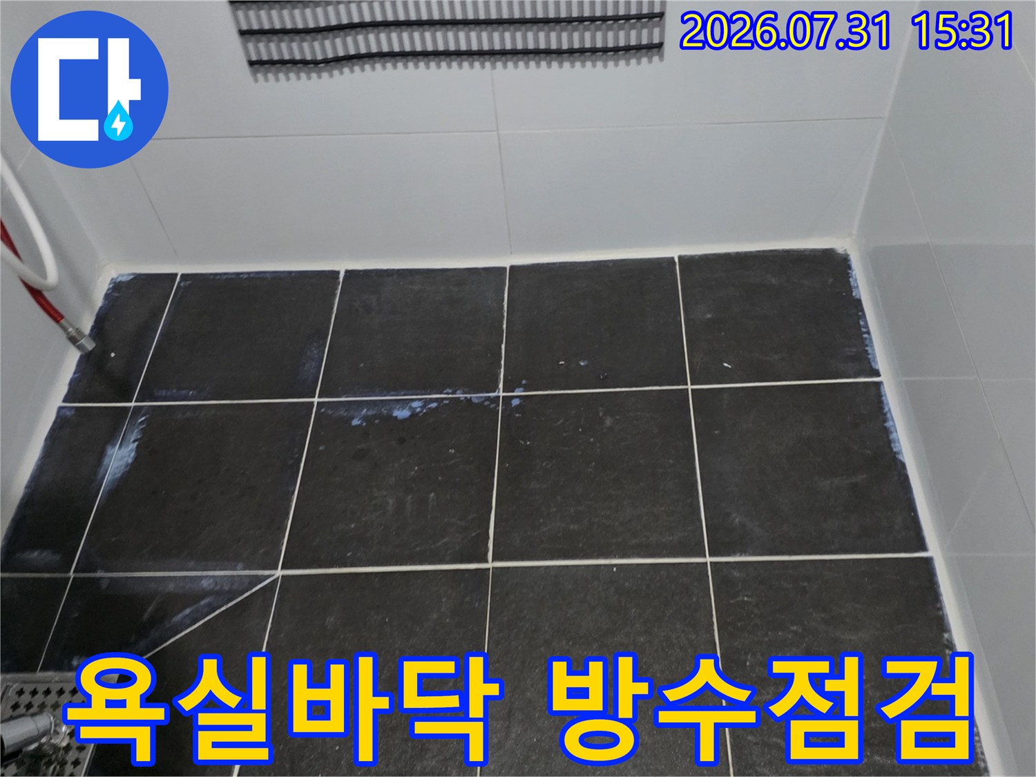 회색 타일이 깔린 욕실 바닥의 누수 점검 현장 모습