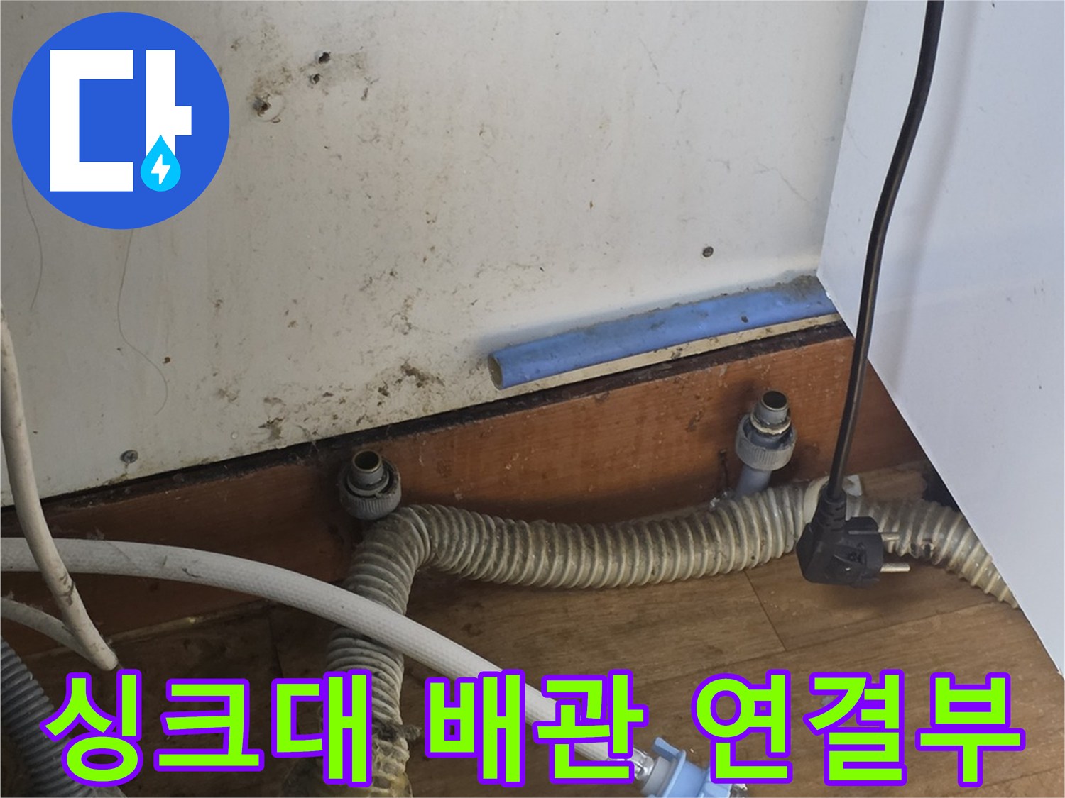 싱크대 아래쪽의 복잡한 급수 및 배수 배관과 작업 도구