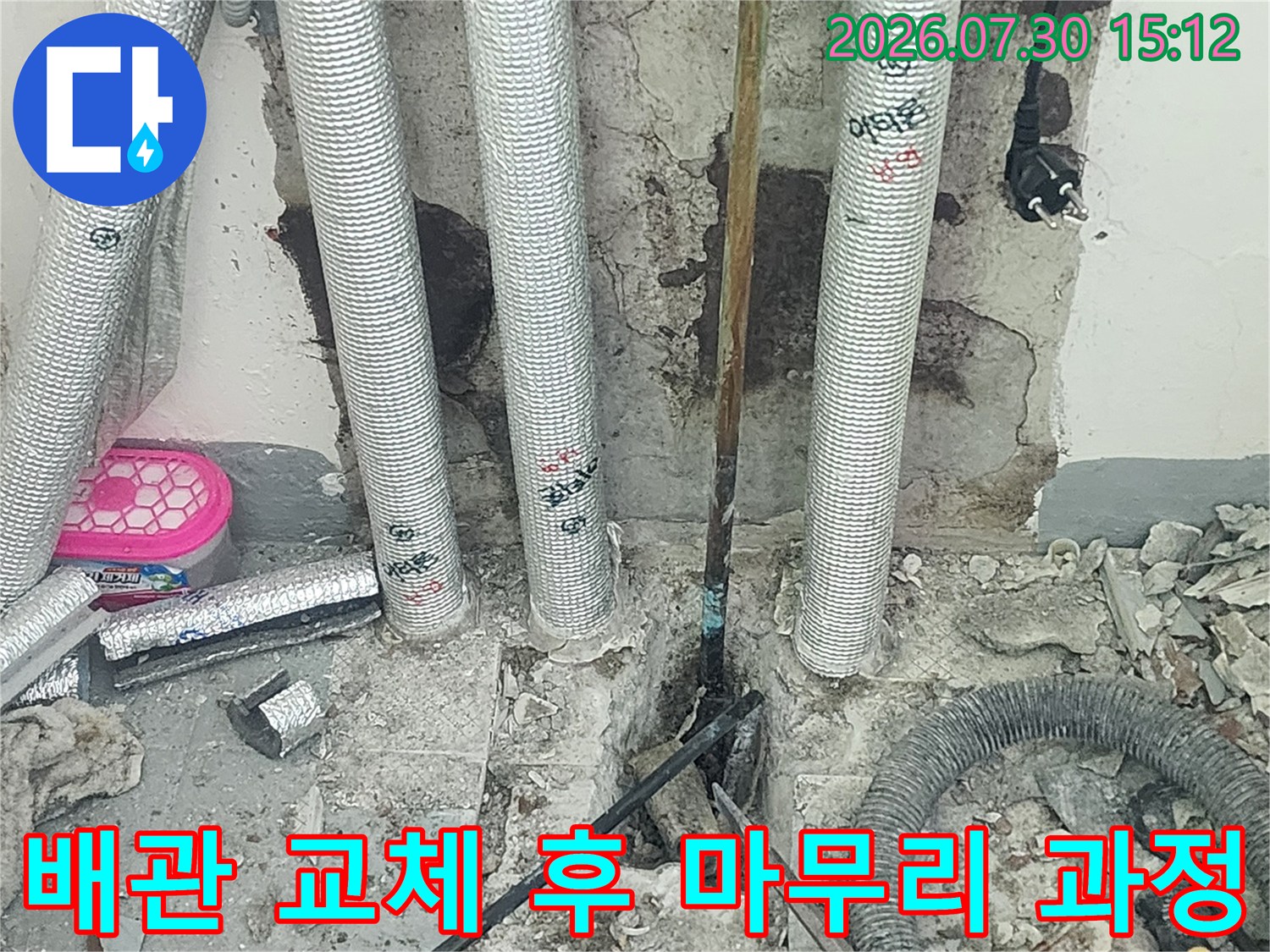 은색 단열재가 씌워진 배관 노출부의 수선 및 마감 현장 모습