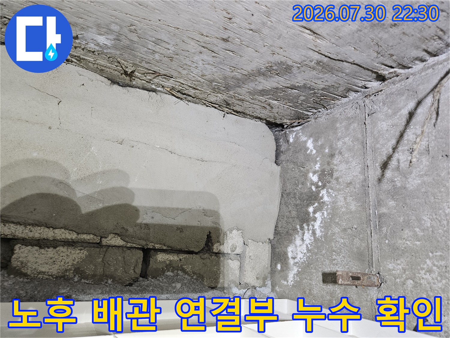 배관 연결 부위의 균열과 습기가 보이는 콘크리트 천장면