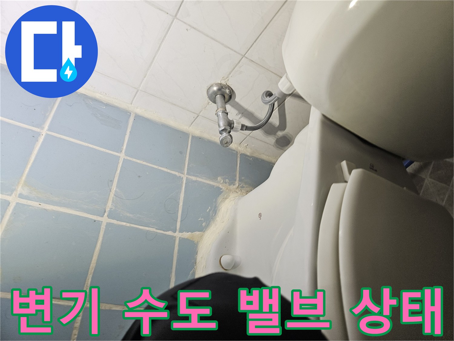 양변기 측면 수도 연결 부속과 벽면 타일 상태를 보여주는 사진입니다.