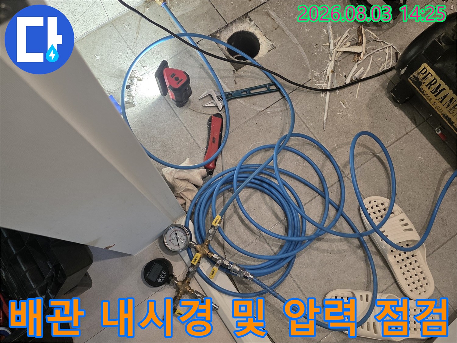 오수배관 주변에 연결된 파란색 호스와 탐지 장비의 세부 모습