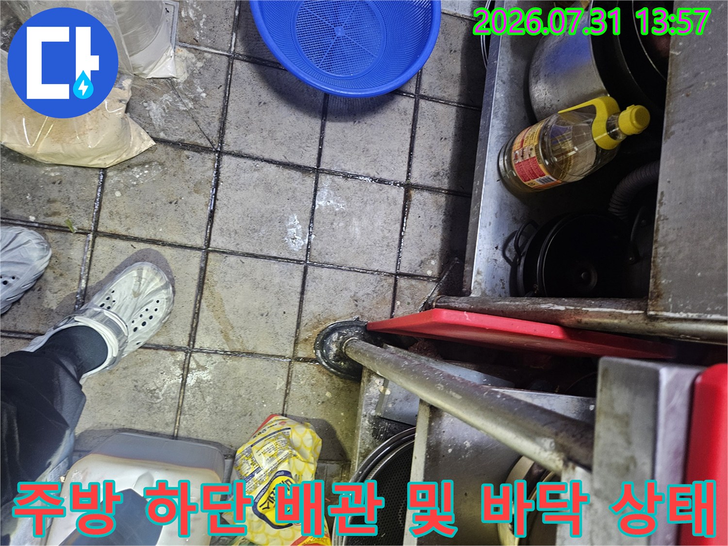 누수가 발생한 것으로 의심되는 주방 구역의 노출 배관과 주변 환경을 점검하는 장면