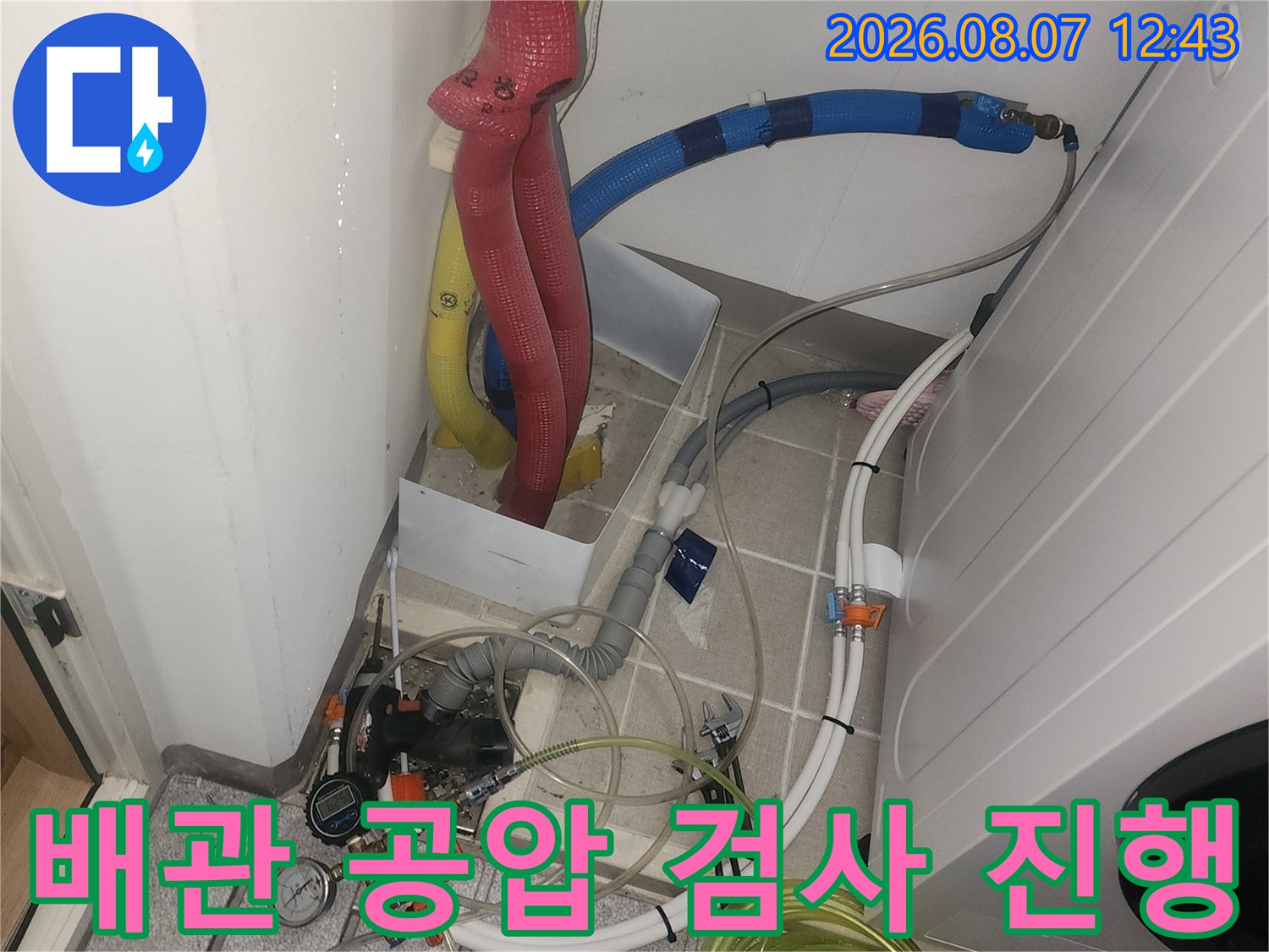 화장실 배관 점검을 위해 압력계를 연결하여 공압 테스트를 진행하는 모습입니다.