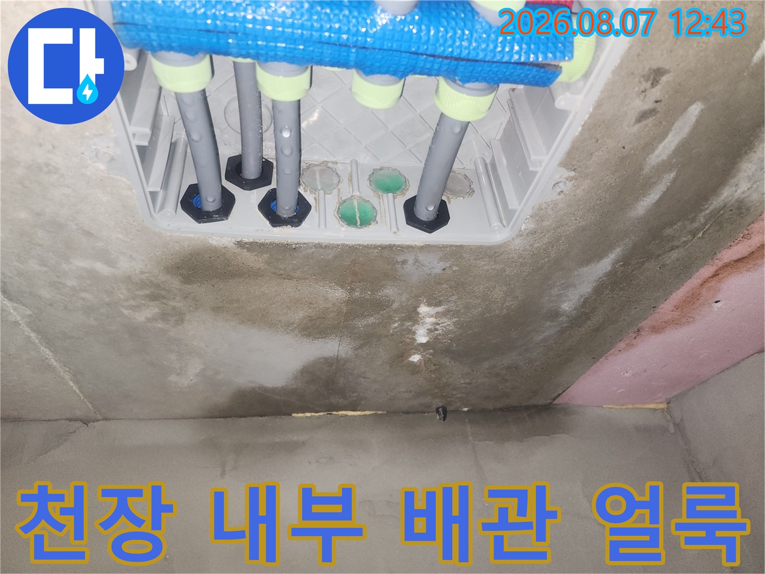 화장실 천장 점검구 내부의 젖은 콘크리트와 배관 연결 부위