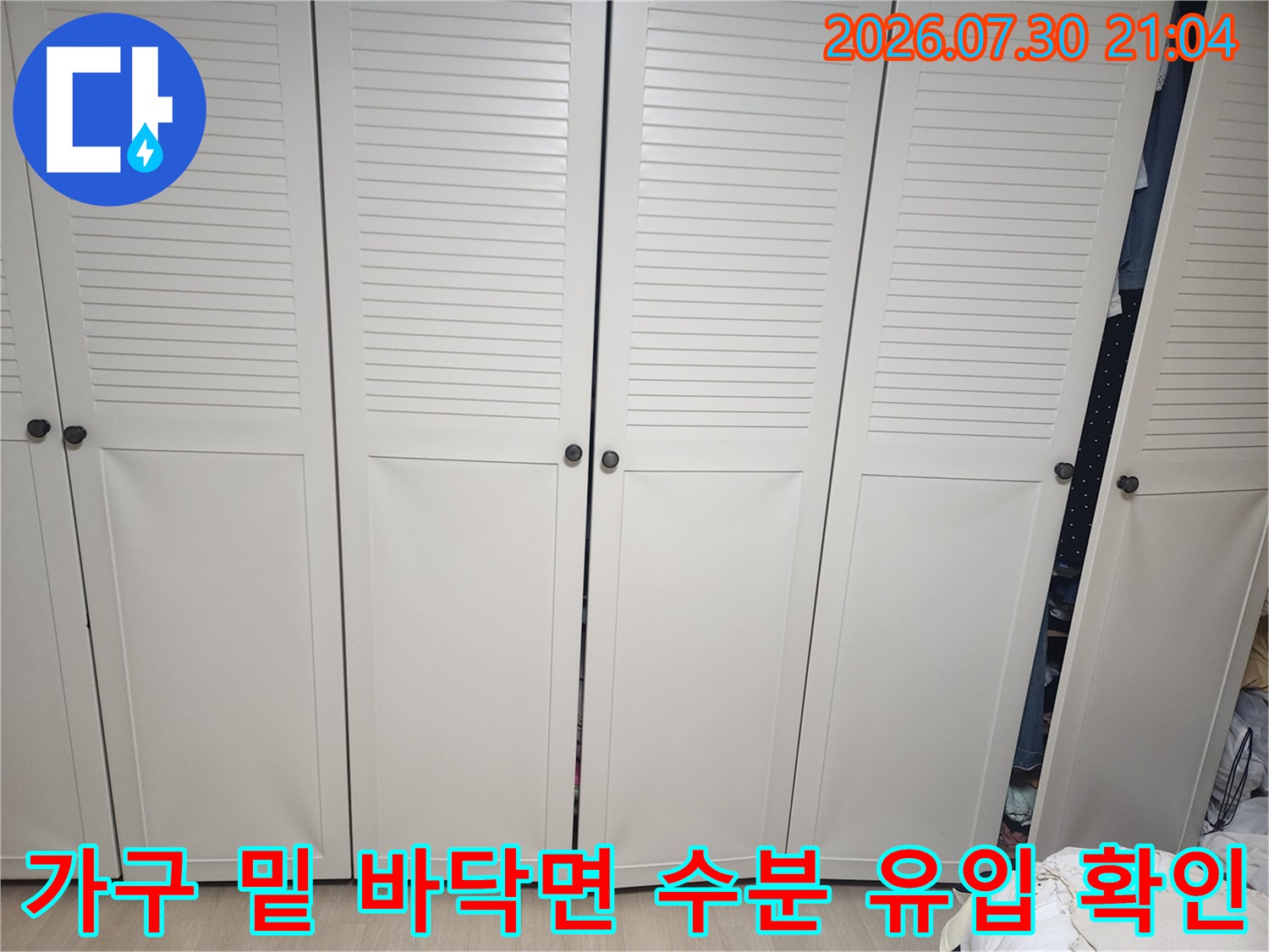 붙박이장 하부와 바닥 마감 부분을 세밀하게 관찰하는 현장 사진