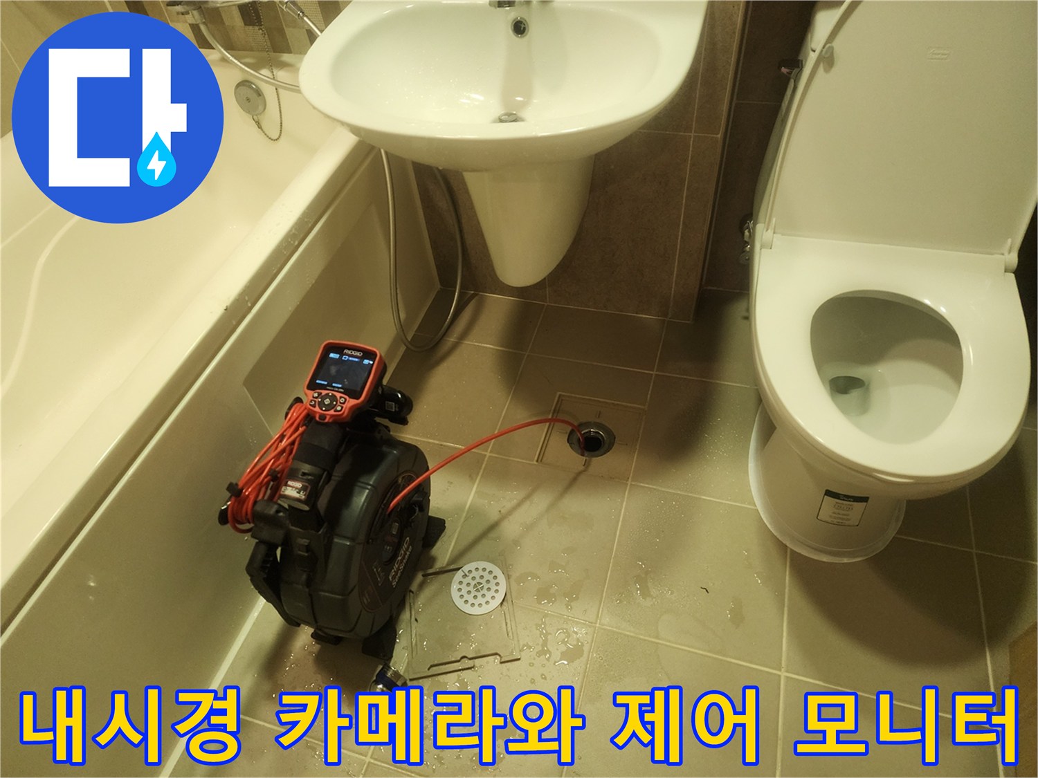 바닥 타일 위에 놓인 빨간색 화면의 내시경 컨트롤러와 케이블