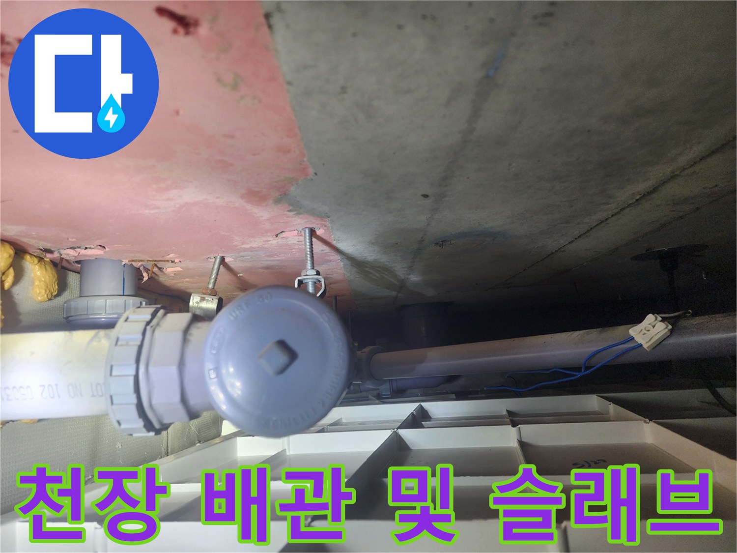 천장 내부 배관과 분홍색 페인트가 칠해진 콘크리트 면