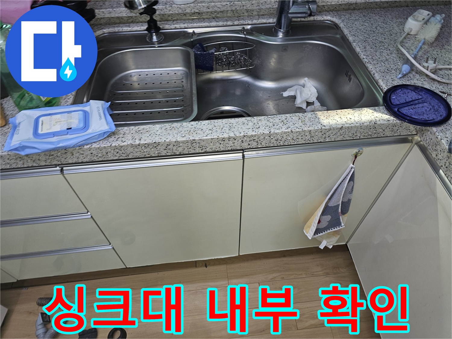 누수가 의심되는 싱크대 수전 및 하부 공간의 모습 - 점검 진행 중