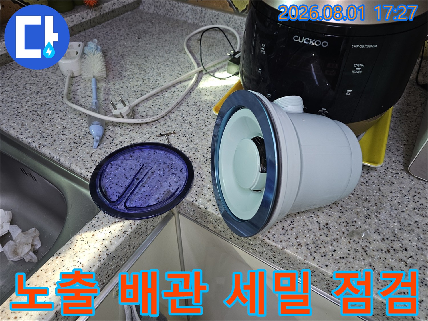 싱크대 하부에 위치한 여러 종류의 배관 연결 상태를 꼼꼼하게 살피는 모습