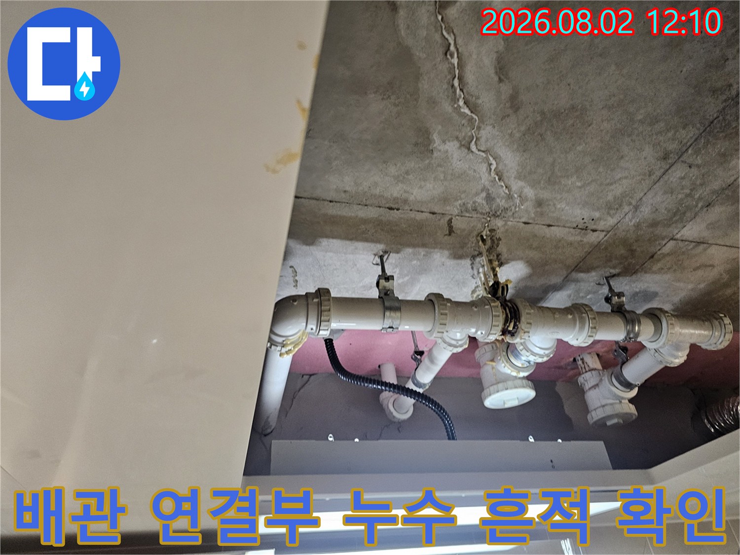 천장 속 노출 배관의 누수 흔적과 오염된 콘크리트 면