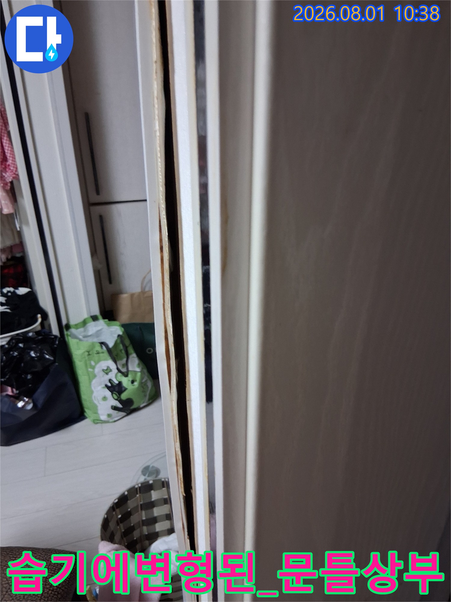 화장실 입구 천장이 젖어 변색되고 마감재가 부풀어 오른 모습