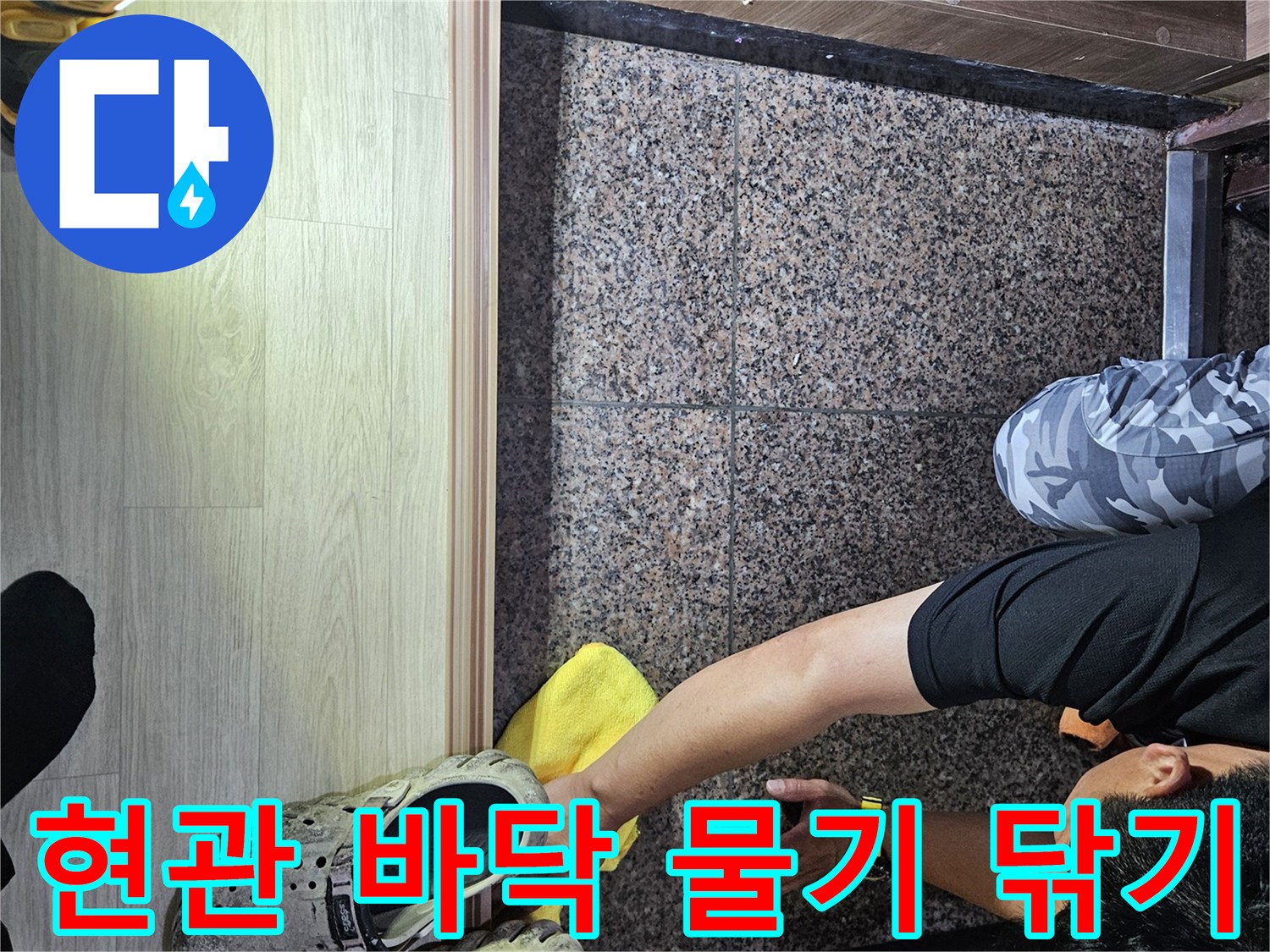 엔지니어가 현관 타일의 습기를 닦아내며 점검을 진행합니다.