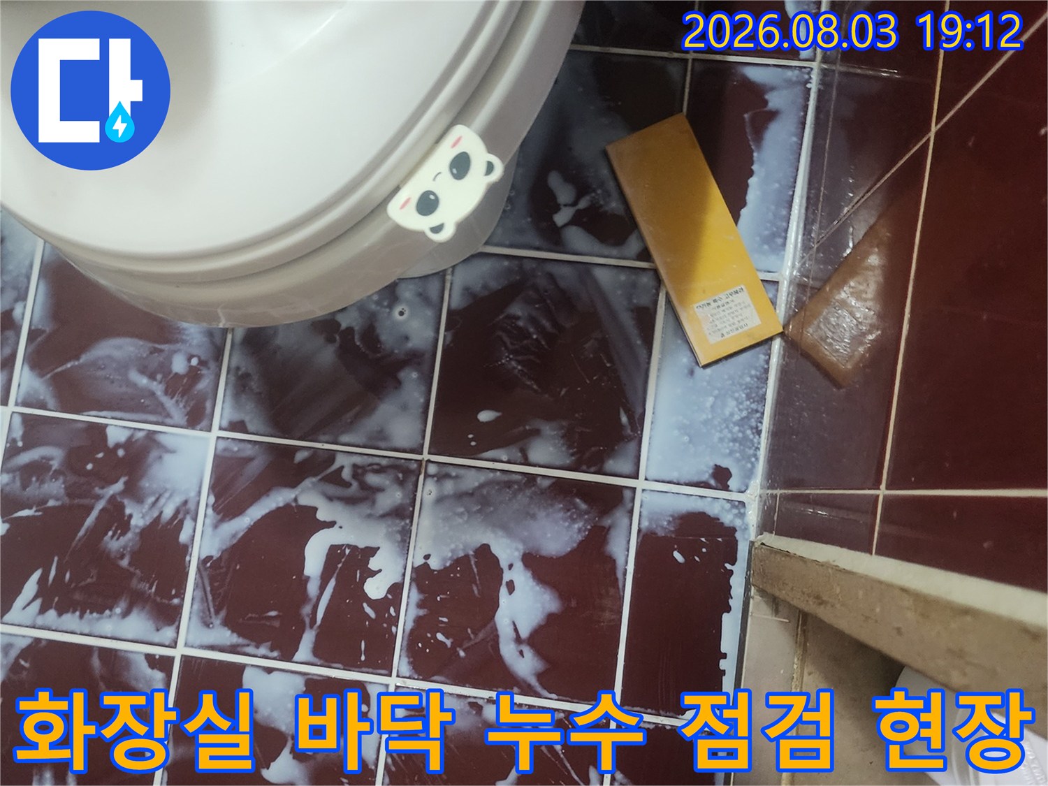 변기 옆 타일 바닥에 고인 물과 배수구 주변의 누수 흔적