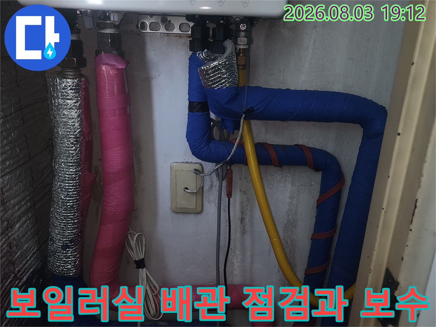 보일러 실내에 설치된 파란색과 분홍색의 단열재로 감싸인 노출 배관 시스템