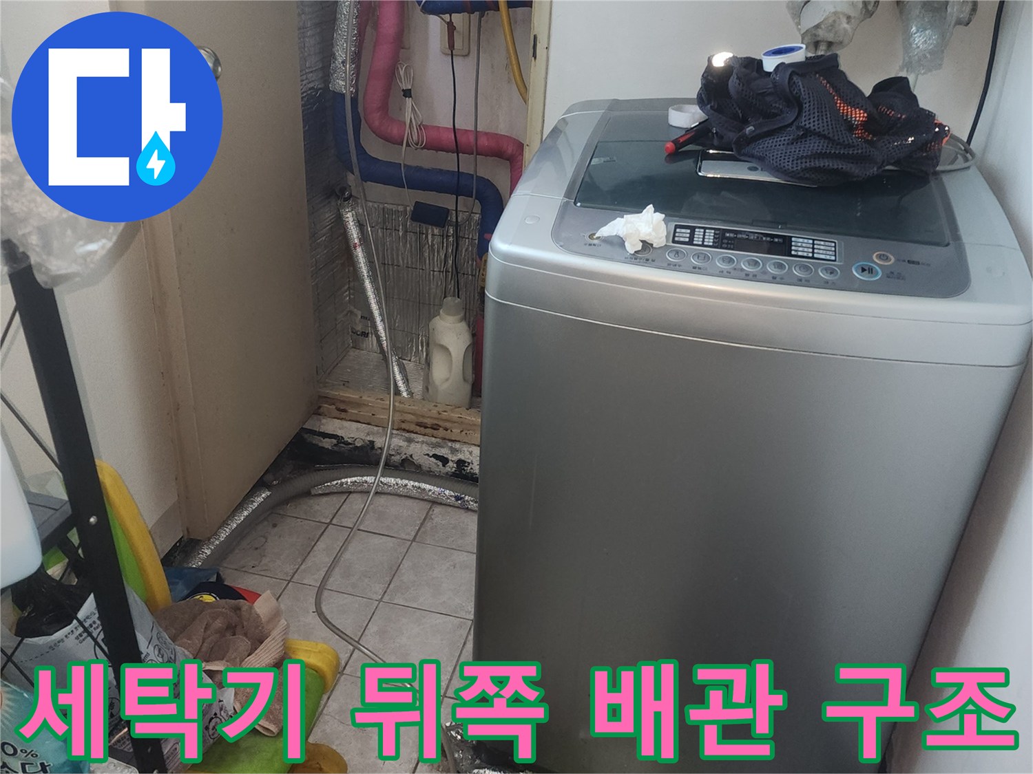 세탁기 밑 공간의 노출된 급배수 관로와 주변 환경