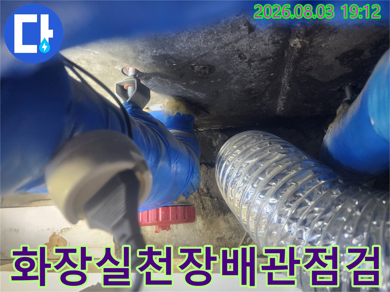 화장실 천장 내부의 파란색 배관과 배수구 주변 점검 모습