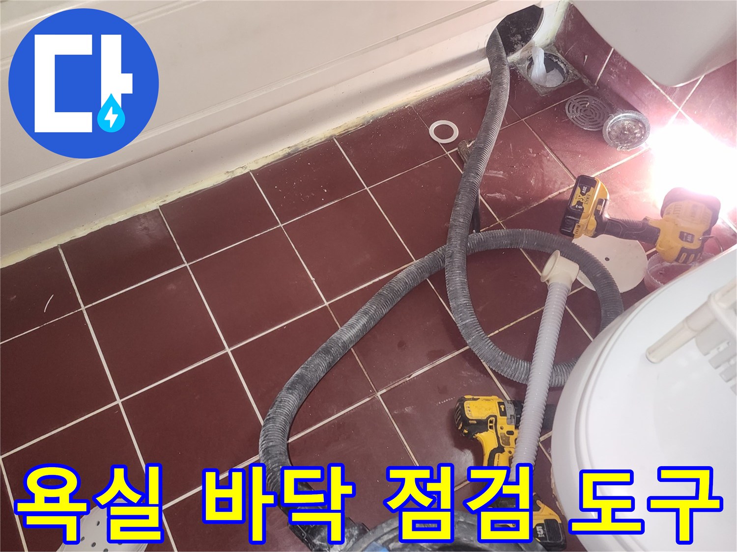 화장실 타일 위 전동 드릴과 흡입 장비-누수 지점 확인 준비