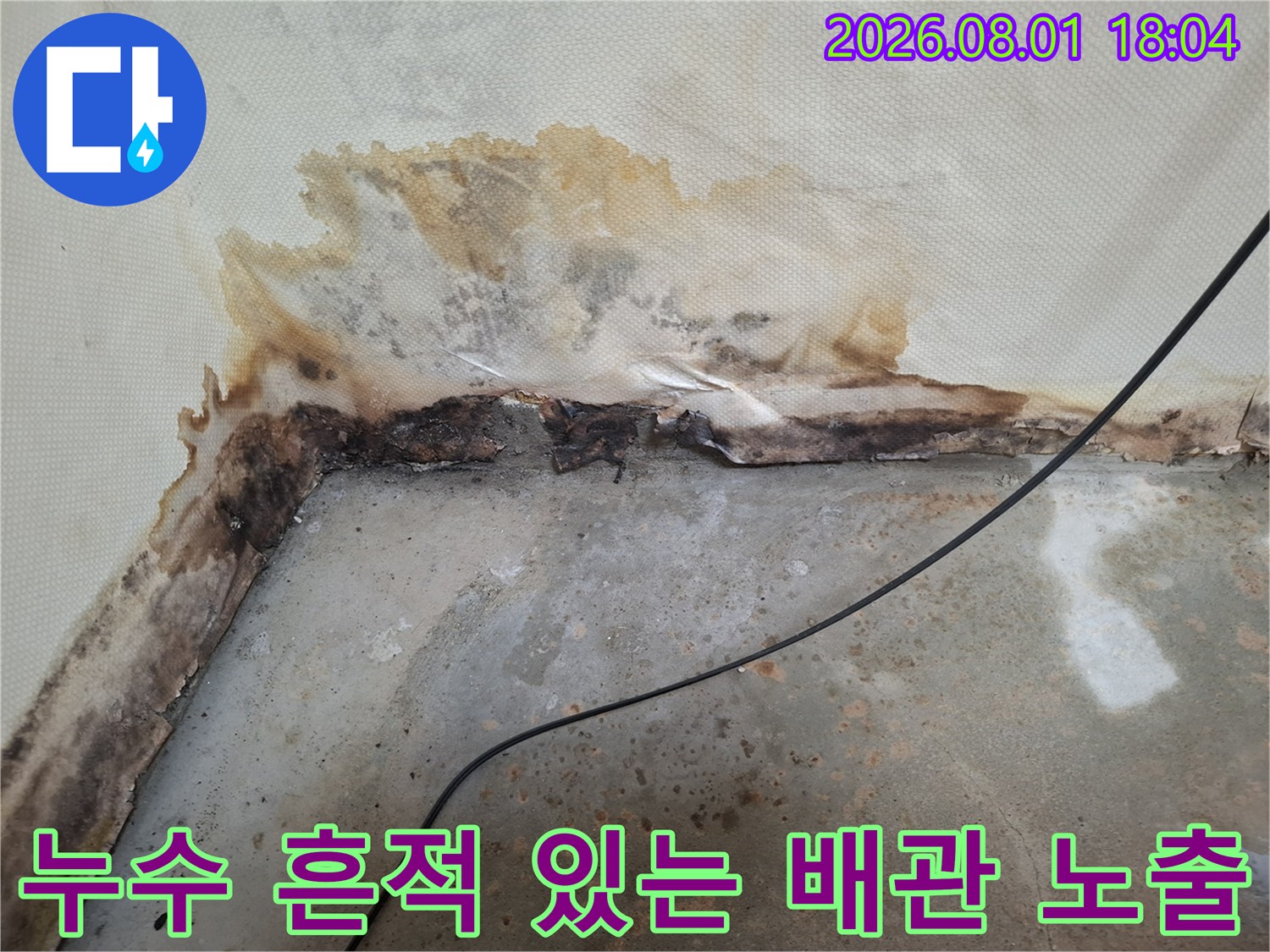 물에 젖어 변색된 천장 마감재와 그 아래로 드러난 파손 의심 배관 구간