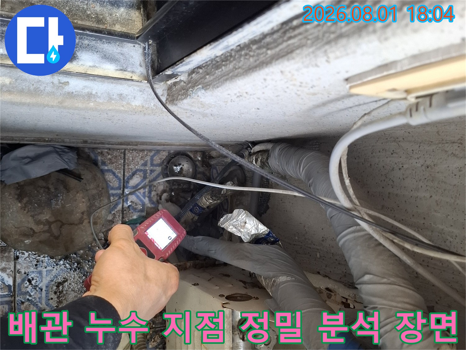 전문가가 배관을 따라가며 탐지 기기로 미세한 누수 반응을 면밀하게 체크하고 있는 모습입니다.