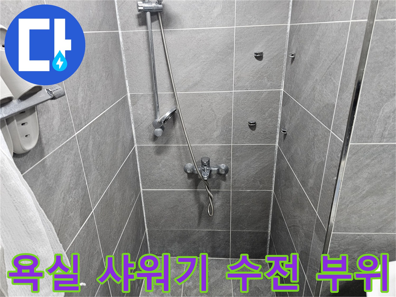 그레이 톤 타일 벽면에 설치된 욕실용 샤워기 장치