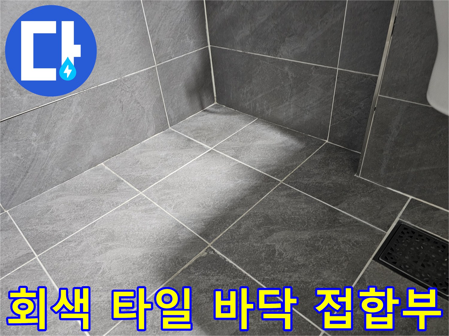 욕실 내부 회색 타일의 마감 상태와 줄눈 부위 상세 컷