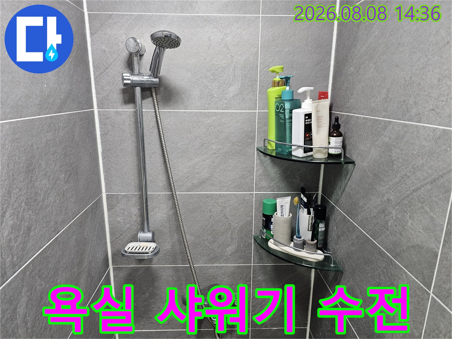 회색 타일 벽면에 설치된 샤워기 수전과 선반