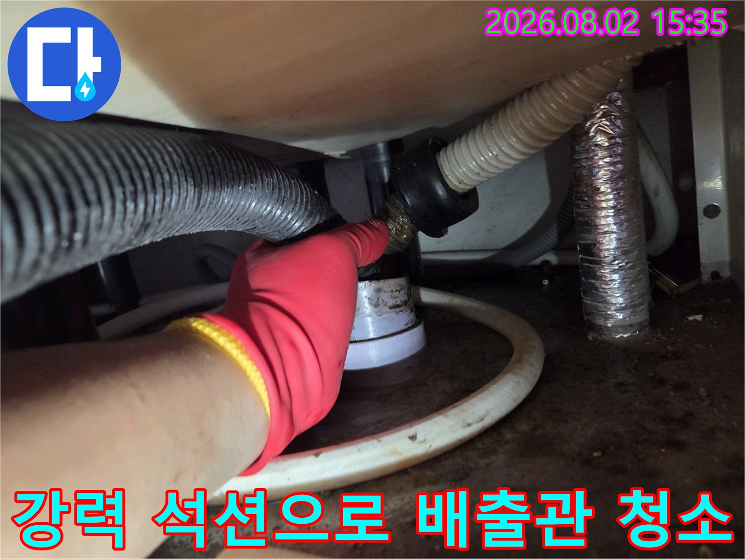 작업자가 빨간 장갑을 끼고 싱크대 아래 배수 호스와 연결된 구간에 석션기 적용