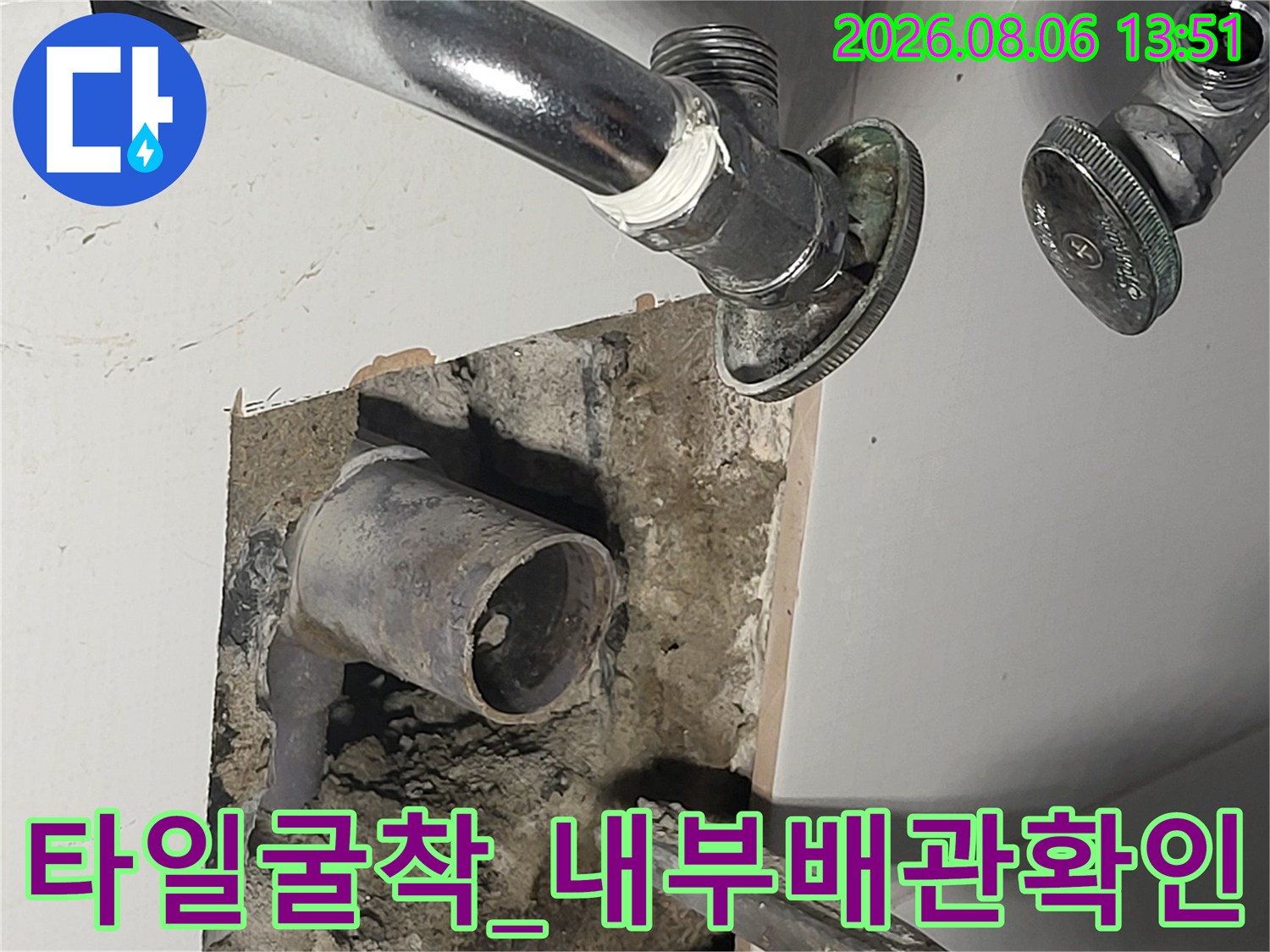 세면대 타일 굴착 후 드러난 매립 배관의 상태를 확인하는 장면