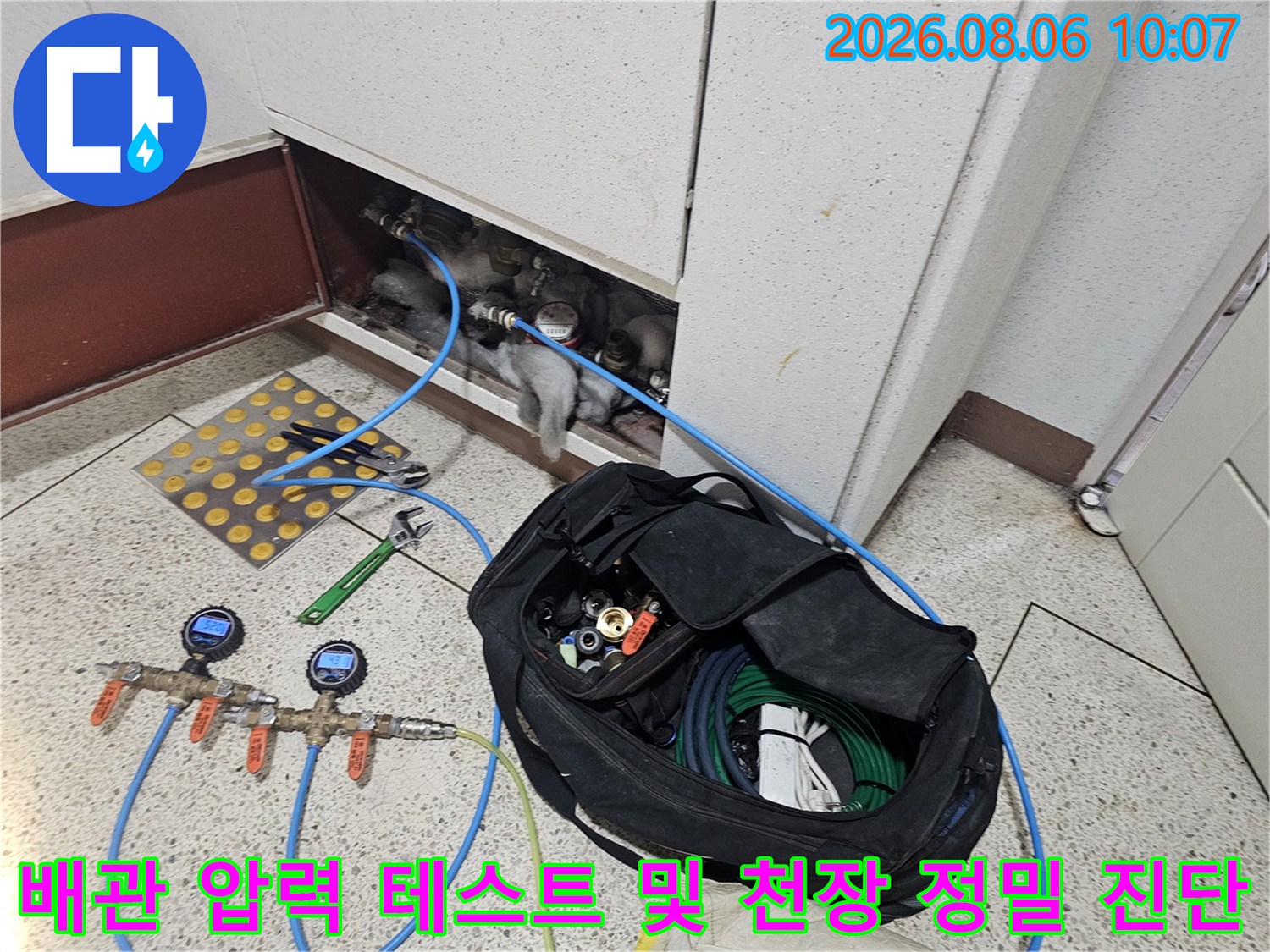 압력 게이지가 연결된 파란색 배관과 점검구 내부의 설비 상태