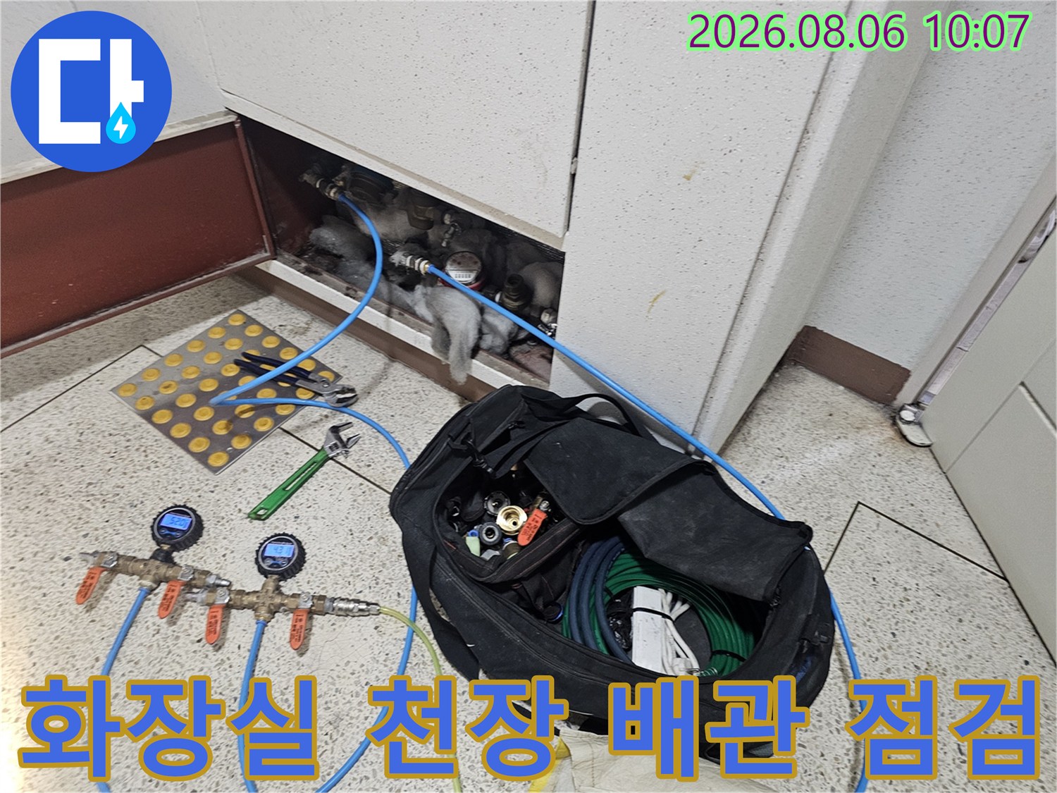 화장실 천장 점검구를 통해 노출된 배관을 정밀 진단하는 모습