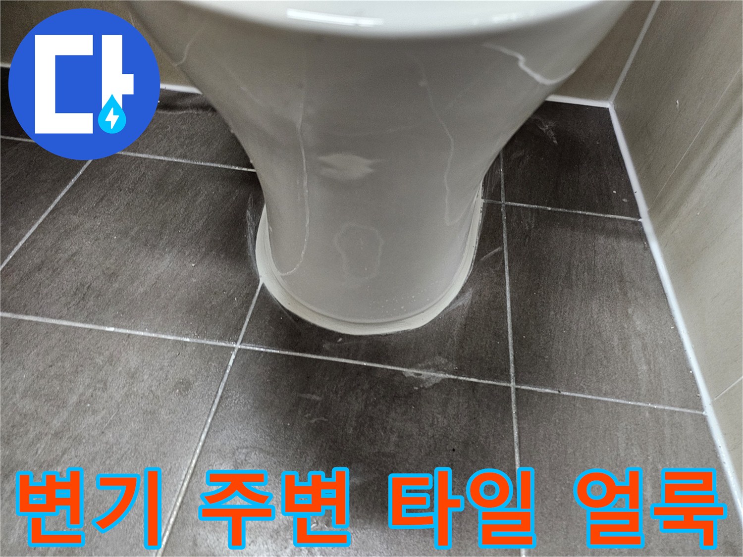 화장실 양변기 하단 타일 면에 나타난 젖은 흔적과 얼룩